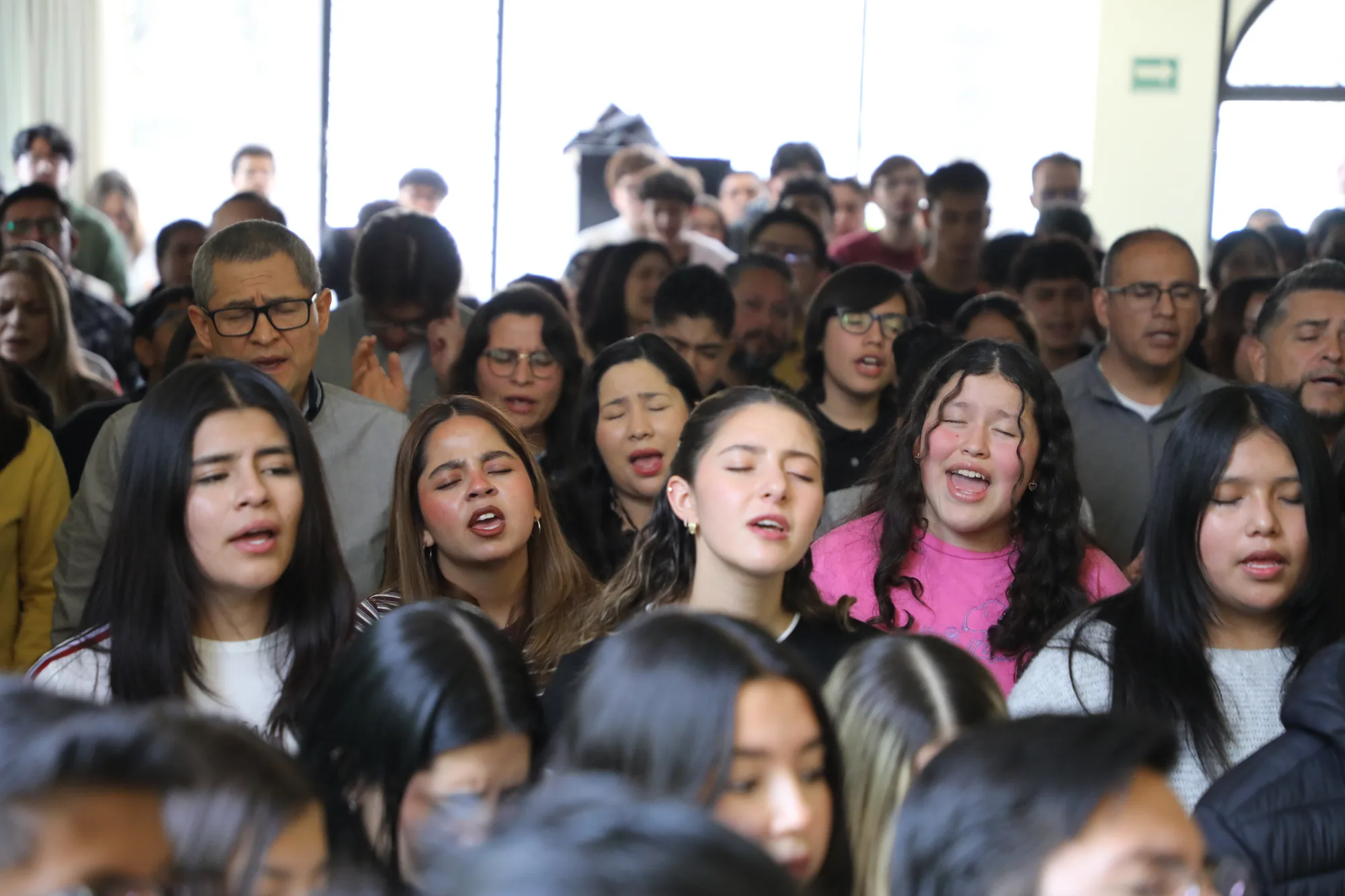 Salón de Casa Zoe lleno de personas en alabanza