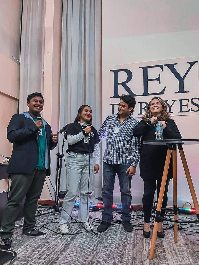 Equipo de alabanza frente al letrero de Rey de Reyes