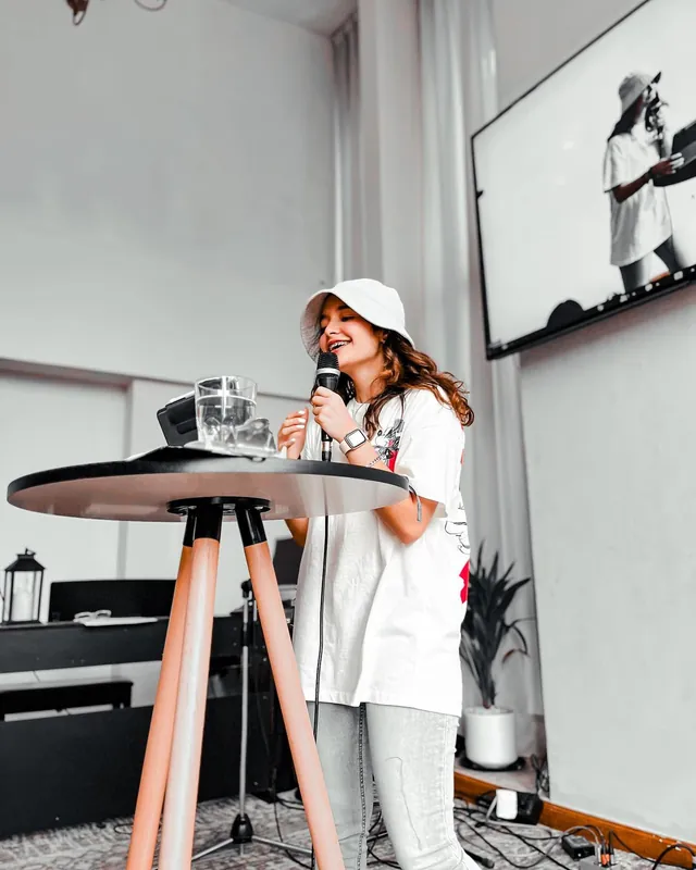 Predicadora con gorra blanca habla con micrófono