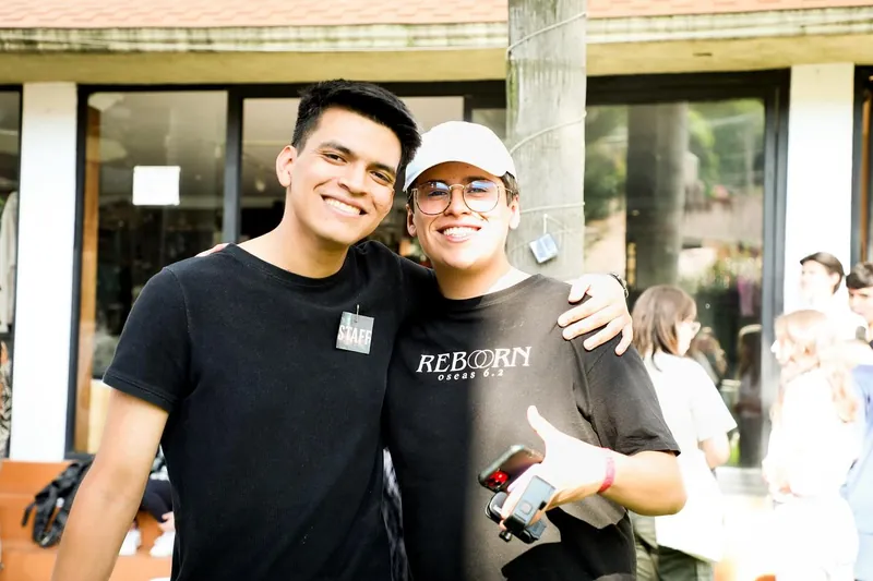 Dos jóvenes del equipo sonríen abrazados
