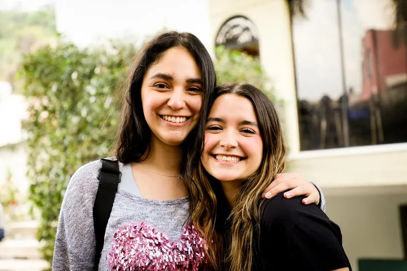 Dos amigas sonríen abrazadas