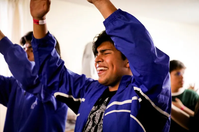 Joven alaba con los brazos en alto y una sonrisa