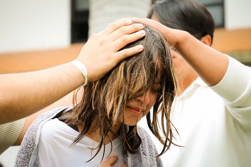 Oran por una joven con las manos sobre su cabeza