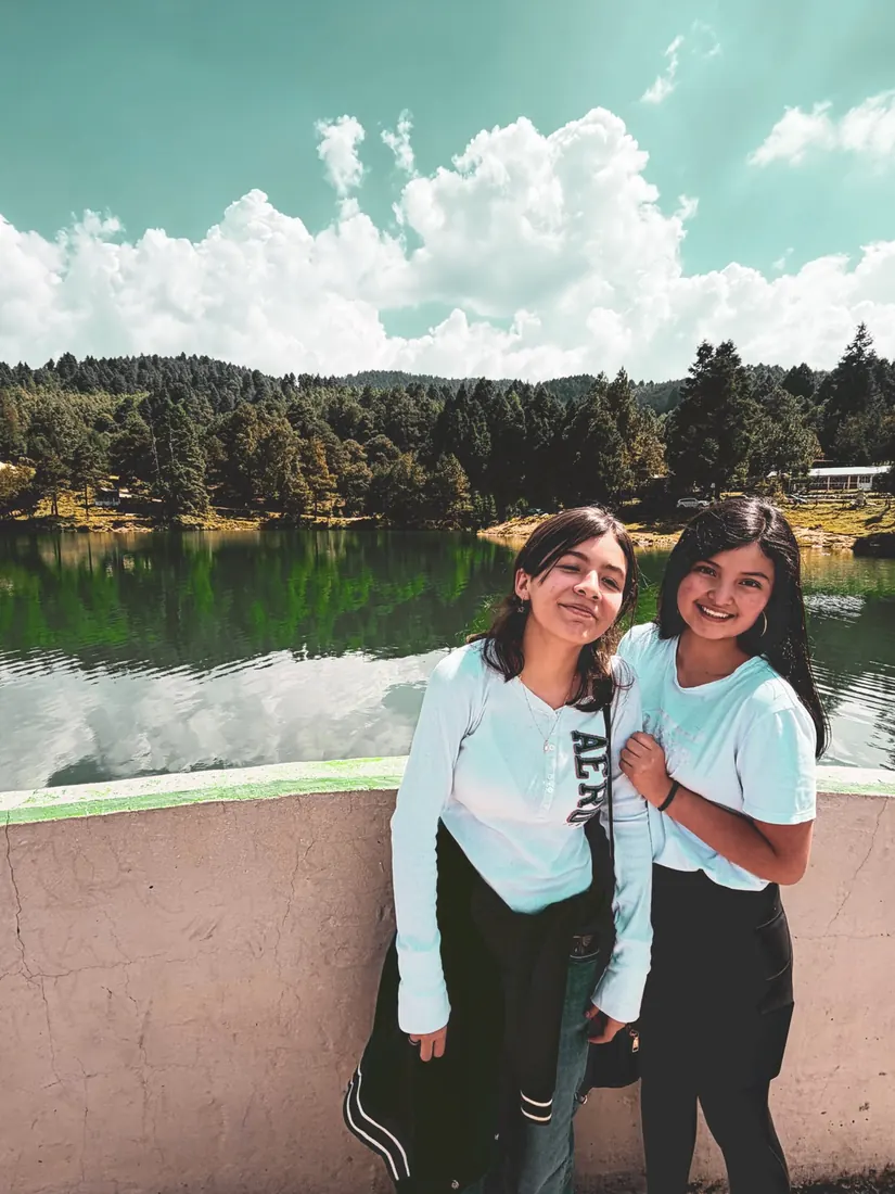 Dos jóvenes sonrientes junto al lago, en la excursión de REBORN 2026.